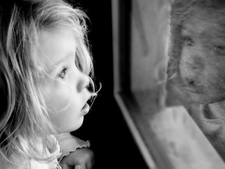 Little_girl_looking_through_window